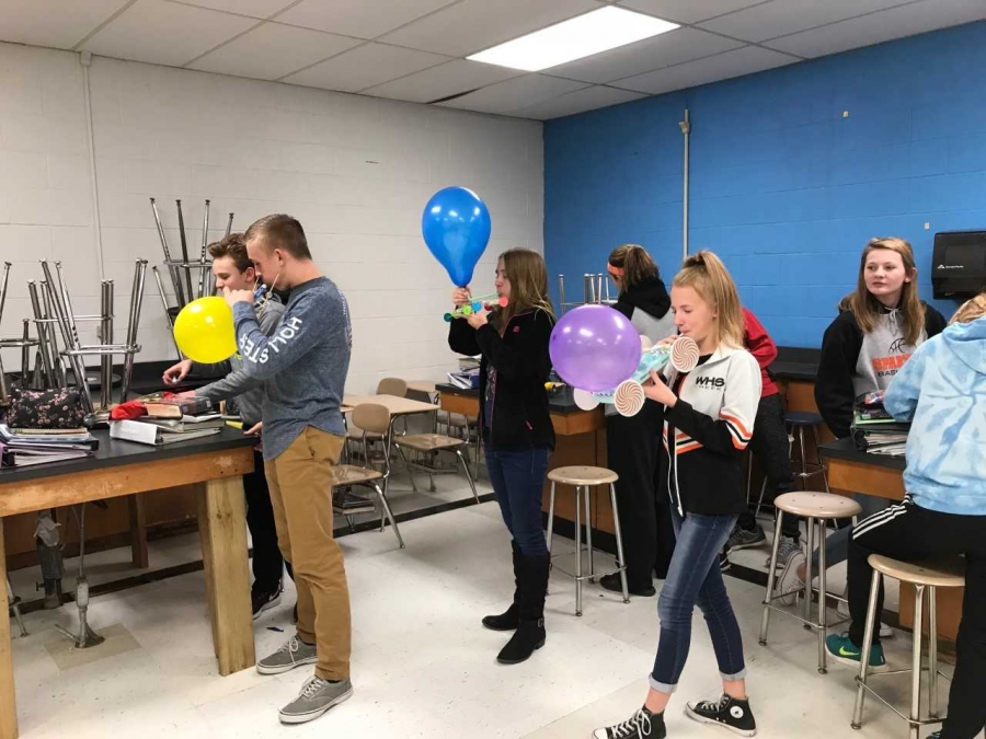 students blowing up balloons